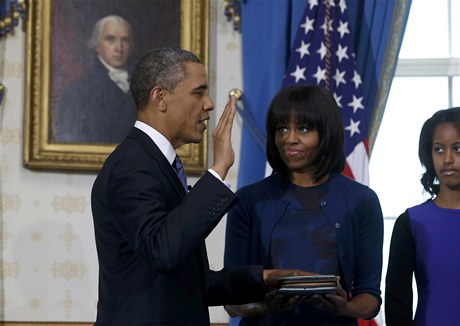 Obama písahá na bibli, kterou pidruje jeho ena Michelle. Vpravo dcera Obamových Malia.