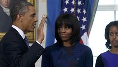 Obama písahá na bibli, kterou pidruje jeho ena Michelle. Vpravo dcera Obamových Malia.