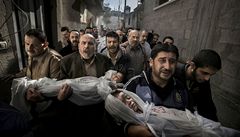 Vítzná fotografie soute World press photo. Na snímku z 20. listopadu 2012 nesou mui v Gaze tla dvou mrtvých dtí.