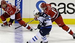 Hokejisté Carolina Hurricanes' Joe Corvo (77) a Jiří Tlustý (19) brání hráče Winnipegu Jets' Bryan Little (18). | na serveru Lidovky.cz | aktuální zprávy