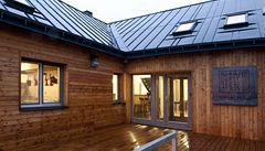 Hlavní vstup do objektu vede pes devnou palubu. 