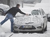 Motorista odklízí sníh z auta na zlínské ulici