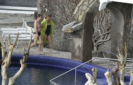 Merkelová s manelem picházejí k hotelovému bazénu.