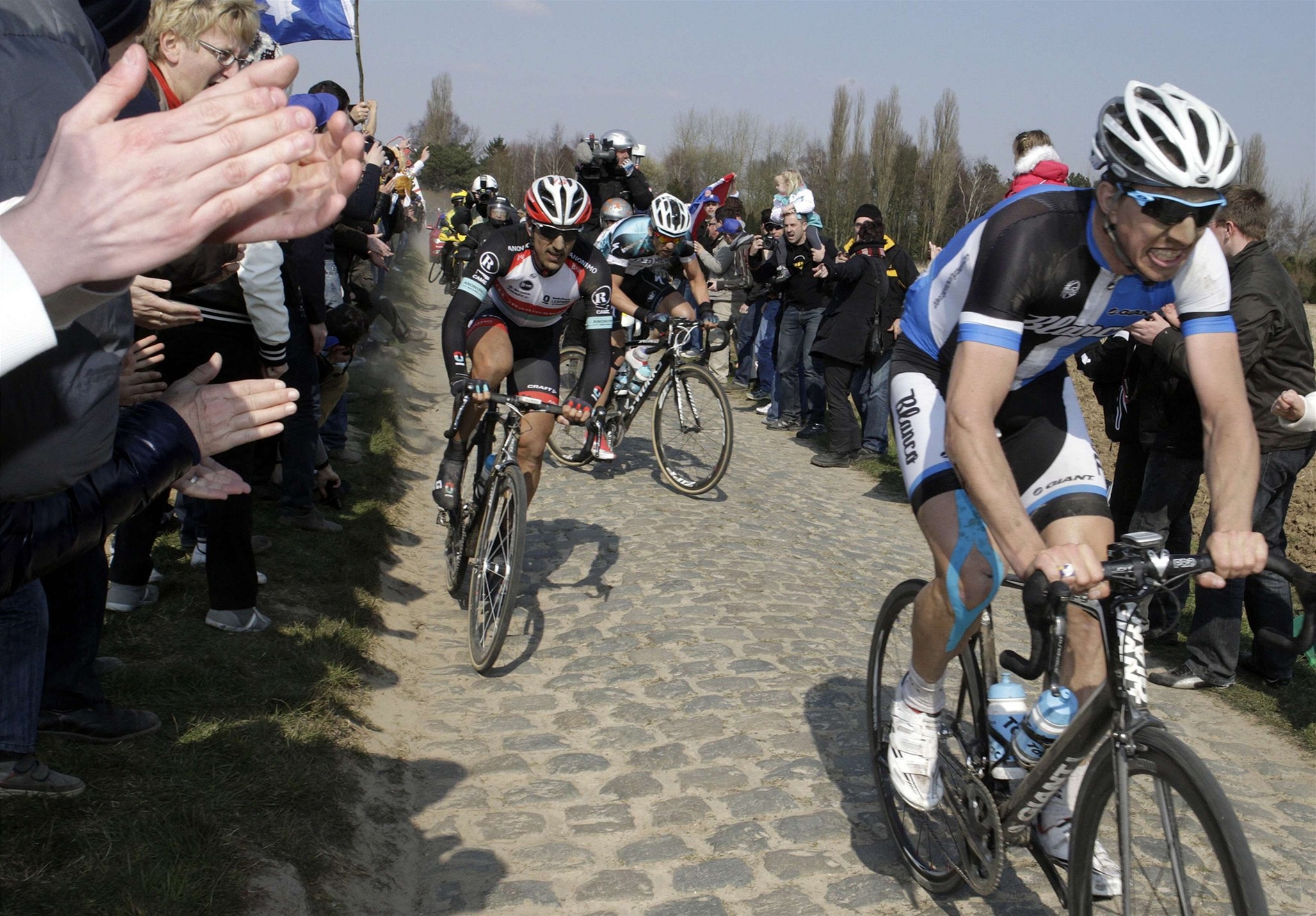Belgický cyklista Sep Vanmarcke (vpravo) a �výcar Fabian Cancellara projí�d�jí diváckou uli�kou 