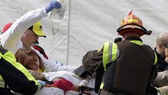 Záchranái odváí zrannou  enu z místa výbuchu na bostonském marathonu.