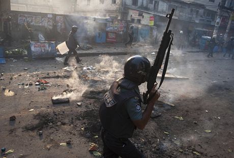 Policista zasahuje pi protestech v Dháce.