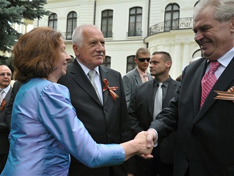 Livia Klausová se zdraví s prezidentem Milošem Zemanem. Uprostřed Václav Klaus. Sešli se na ruské ambasádě.