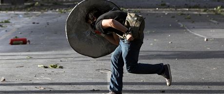 Demonstrant se kryje títem ped poádkovými silami behm nepokoj v Ankae. 