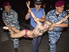 Scéna jako z baletu. Poádková policie zasahuje proti Femen. 