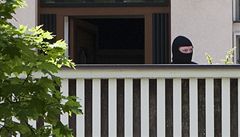 Policista ÚOOZ za mohutnou zdí Rittigovy vily.