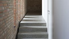 Decentn� osv�tlená chodba v p�ízemí ukazuje kontrast mezi p�vodním zdivem a novou vestavbou. 