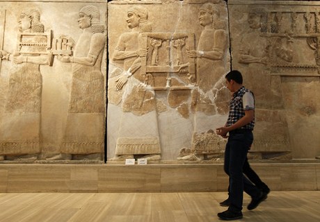 Mu prochází kolem kamenných reliéf v Národním muzeu v Iráku.