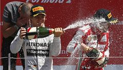 Nico Rosberg (vlevo) vyhrál Velkou cenu Británie a "sprchuje" Alonsa.