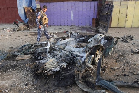 Irácký voják obhlíí vrak auta, ve kterém se odpálili sebevraední atentátníci.