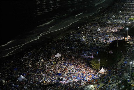 Lidé stanují a pespávají na plái Copacabana. ekají na mi papee Frantika.