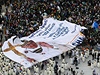 Poutníci a pedstavitelé katolické církve drí nad hlavou obí transparent s papeovou podobiznou