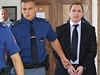 Policisté vedou Petra Kotta zpt do soudní sín. 