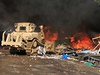 Buldozer se potýká s hoícími zbytky protestního tábora