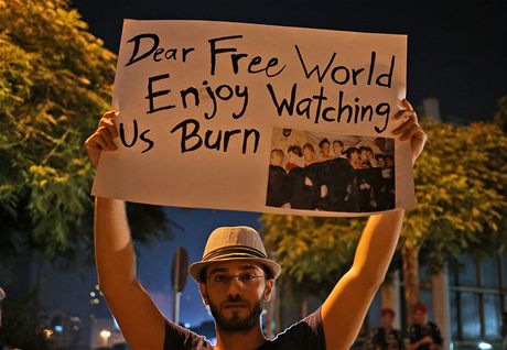 Syan ijící v libanonském Bejrútu drí nad hlavou transparent s nápisem "Drahý svobodný svte, uij si sledovat, jak hoíme"  