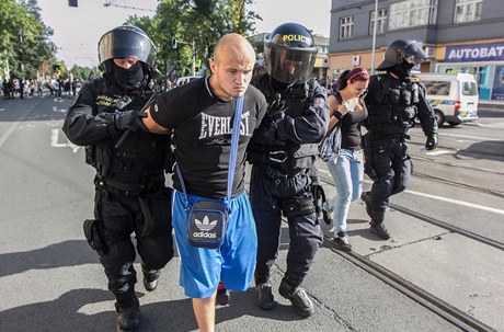 V Ostravě létají dělbuchy i kameny, na místě jsou i psovodi a těžkooděnci, kteří se stále snaží dav radikálů vytlačit zpět. Policie odvedla pět zadržených lidí. 