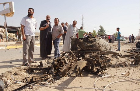 Civilisté se shromaují kolem trosek po výbuchu bomby v Bagdádu. 