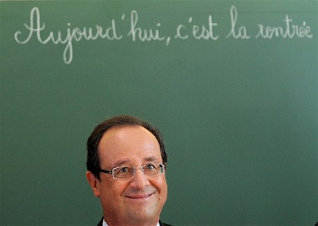 Prezident Hollande se usmívá pod nápisem "Dnes se vracíme" (do koly)