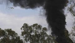 K budov� obchodního domu, ze které stoupá kou�, mí�í helikoptéra