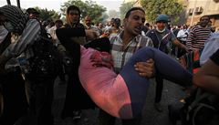 �len muslimského bratrstva prchá p�ed plynem s �enou v náru�í.