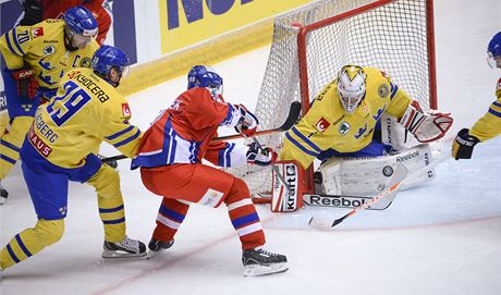 eský hokejista Tomá Rolinek (uprosted v erveném) stílí na brankáe védska Henrika Karlssona 