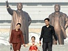 Severokorejská rodina. Na pozadí usmvavé sochy Kim Ir-sena a Kim ong-ila