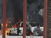 Obyvatelé Benghází se schovávají za auty bhem ozbrojených stet mezi lilbyjskou armádou a islamisty