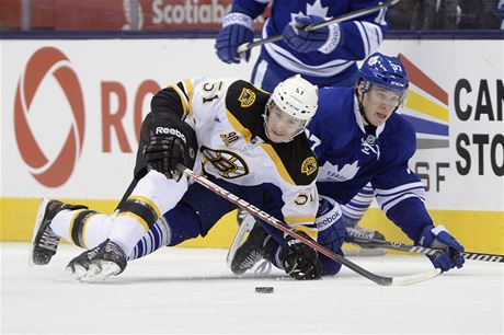 Ryan Spooner z Bostonu bojuje s Carter Ashtonem z Toronta o puk.