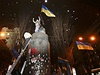 Lidé oslavují strení Leninovy sochy na piedestalu, kde jet donedávna stála.