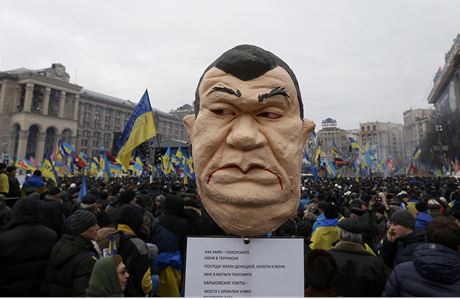 Demonstrující nesou zesmující figurínu prezidenta Janukovye. 