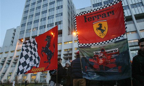 Vlajky ferrari na podporu Schumachera ped nemocnicí v Grenoblu.