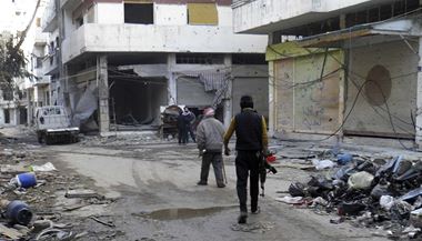 Syrt povstalci a civilist kr po zniench ulicch oblhanho Homsu.