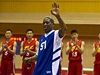 Dennis Rodman mává Kim ong-unovi. V pozadí nastoupený severokorejský basketbalový tým.