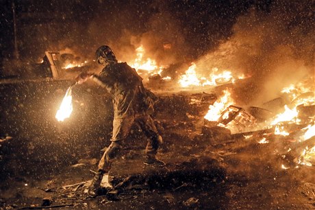 Pouliní válka v Kyjev. Ulice jsou v plamenech, demonstrant vrhá Molotovv koktejl.