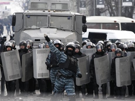 len bezpenostních jednotek hází kámen smrem k protivládním demonstrantm.