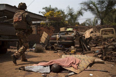 Francouzský voják prochází kolem tla obti jednoho z posledních útok poblí letit u msta Bangui.