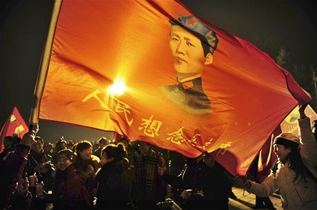 íané s rudou vlajkou, na ní je vyobrazen mladý Mao Ce-tung.
