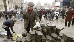 Lidé na Majdanu si p�ipravují zbran�: rozbíjejí dla�bu.