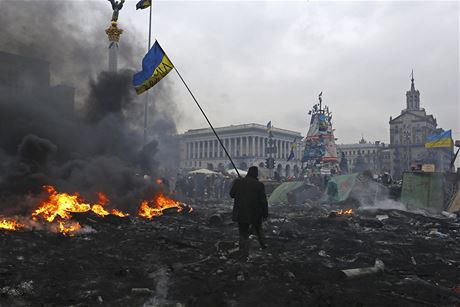 Demonstrant s ukrajinskou vlajkou na troskch splench barikd na Majdanu.