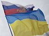 Vlajíí ukrajinská a ruská vlajka vedle sochy Vladimira Iljie Lenina.