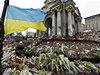 Ukrajinská vlajka vlaje nad improvizovaným památníkem obtí násilí.