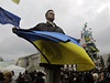 Demonstrant s ukrajinskou vlajkou na kyjevském námstí Nezávislosti. 