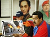 Prezident Maduro ukazuje peliv vybrané snímky zachycující protivládní nepokoje. V pozadí portréty Huga Cháveze a Simóna Bolívara.
