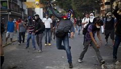 Demonstranti házejí kameny na Národní Bolívarovskou policii bhem protestu v Caracasu.
