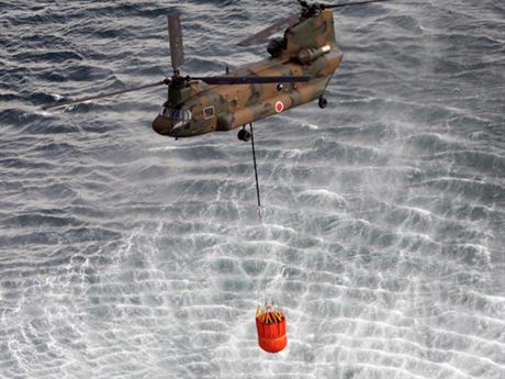 Vrtulník CH-47 Chinook nabírá mořskou vodu, aby ze vzduchu pokropil „bazén“ s vyhořelým palivem nad reaktorem 3 jaderné elektrárny Fukušima 1.