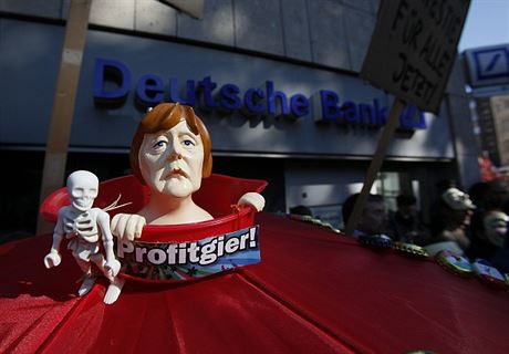Figurka kancléřky Angely Merkelové coby zosobnění „chamtivosti“. Snímek z protestů v Kolíně nad Rýnem, které proběhly 15. října.